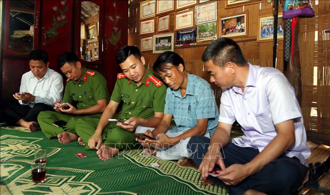 Cán bộ Viettel, Công an xã Thượng Trạch (Quảng Trị) về tận thôn bản hỗ trợ người dân trong các thủ tục hành chính. (Ảnh: Tá Chuyên/TTXVN)